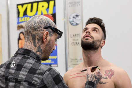 MILAN, iTALY - FEBRUARY 9, 2018: Professional tattoer works at Milan Tattoo Convention, international annual event dedicated to the world of tattoos and body painting in Milan, Italy.のeditorial素材
