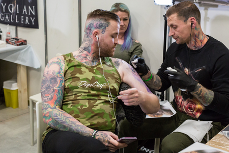 MILAN, iTALY - FEBRUARY 9, 2018: Professional tattooer works at Milan Tattoo Convention, international annual event dedicated to tattoos and body painting in Milan, Italy.のeditorial素材