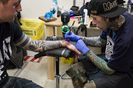MILAN, iTALY - FEBRUARY 9, 2018: Professional tattooer works at Milan Tattoo Convention, international annual event dedicated to tattoos and body painting in Milan, Italy.のeditorial素材