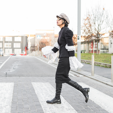 Beautiful young Indian woman crossing the street. Street fashion and style.の写真素材