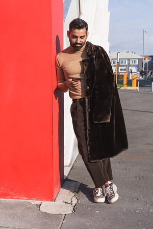 Handsome Indian man texting in an urban context. Street fashion and style.の写真素材