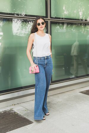 MILAN, ITALY - JUNE 15: Fashionable woman poses outside Armani fashion show during Milan Men's Fashion Week on JUNE 15, 2019 in Milan.のeditorial素材