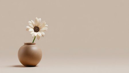 A single white daisy in a small, round brown vase against a soft, neutral backgroundの素材