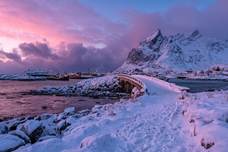 Snowy bridge leads into a harbor village, under a vibrant pink and purple sunsetの素材