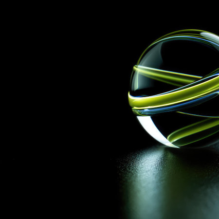 A glass sphere with green and blue ribbon-like elements on a dark backgroundの素材