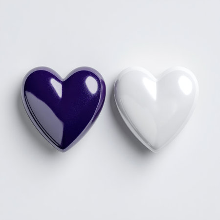 Two glossy, heart-shaped objects, one purple, one white, sit on a neutral backgroundの素材