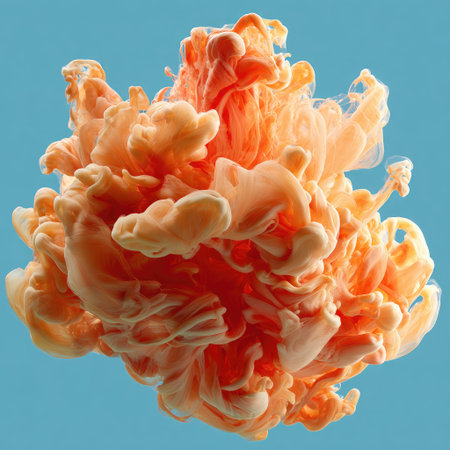 Soft orange ink swirls and blooms in water against a light blue background, creating ethereal cloudsの素材