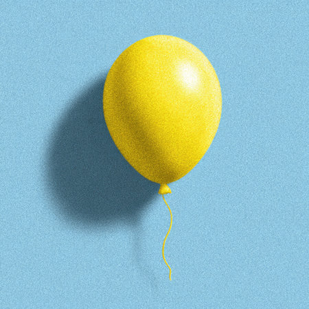A yellow balloon floats in front of a blue textured background, casting a soft shadowの素材