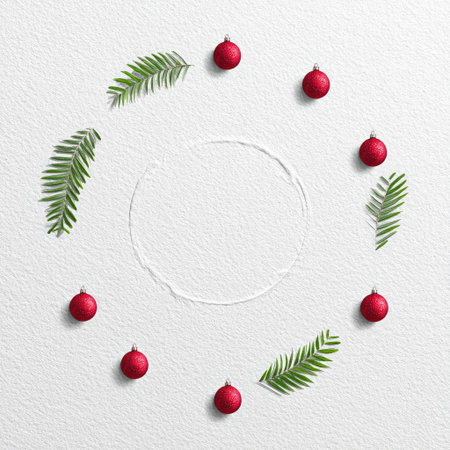 Festive circle design Red baubles and green foliage arranged on a textured white surfaceの素材