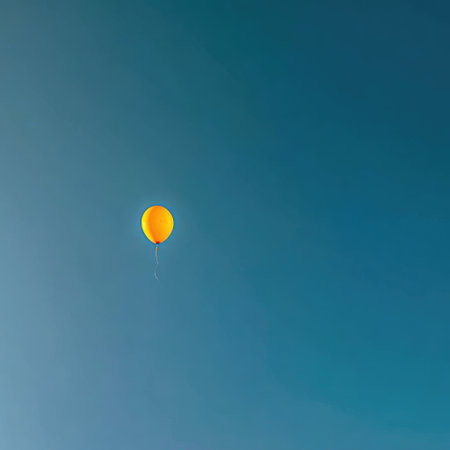 Single yellow balloon against a vast, gradient blue sky. Simple, isolated, and upliftingの素材