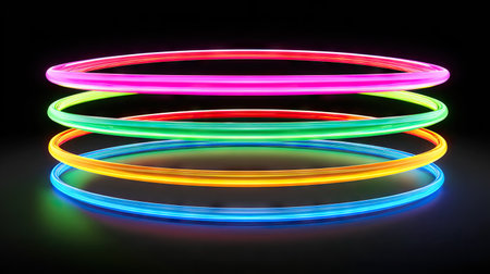 Several brightly colored neon hoops are arranged horizontally, showcasing vibrant hues of red, pink, green, yellow, and blue. The composition, set against a dark backdrop, creates a striking visual impact. The image, with its glowing elements, may be suitable for advertising, design projects, and visual concepts.の素材