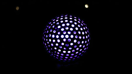 A luminescent sphere, illuminated with circular lights, is centered against a dark background. The image showcases a smooth, glossy texture with vibrant purple and white tones. This modern design suggests a futuristic, conceptual theme, suitable for digital art, or various commercial uses.の素材