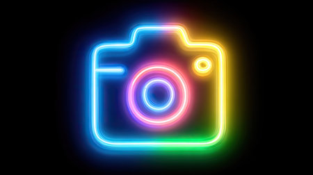 A vibrant neon camera icon shines against a dark backdrop. The image features a bright, multi-colored glow, highlighting the camera's outline and lens. This graphic style suggests modern design applications, suitable for digital media, presentations, and creative projects. Its simplicity allows for diverse editorial and commercial usages.の素材