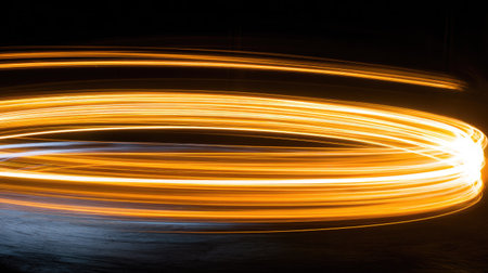 This image features abstract light trails forming swirling patterns in orange and white against a black background. The visual characteristics include streaks of light, suggesting motion and energy. The composition presents a sense of movement. This could be used for various commercial projects related to technology or design.の素材