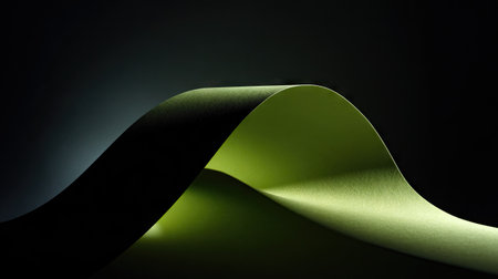 green curved paper on dark background, closeup of photo with soft focusの素材