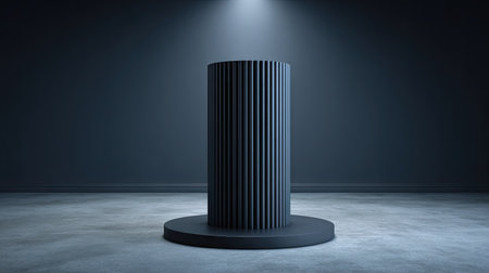 A dark, cylindrical podium stands centered against a deep gray backdrop, illuminated by a focused overhead spotlight. The vertical lines create a textured effect, contrasting with the smooth base and floor. The presentation is simple, with minimal elements. Suitable for showcasing products or editorial concepts.の素材
