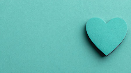 A single turquoise heart shape rests against a solid turquoise backdrop. The image utilizes a simple composition and flat lighting, emphasizing the form. Suitable for various design applications, the image is versatile for both commercial and editorial uses. This abstract design could be used in various projects.の素材