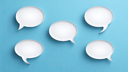 Five stylized speech bubbles are arranged against a bright blue backdrop. The bubbles are rendered in white, with subtle shadows suggesting depth. The overall composition is clean and minimalist, offering ample copy space for text. Suitable for design, communication, or marketing materials.の素材