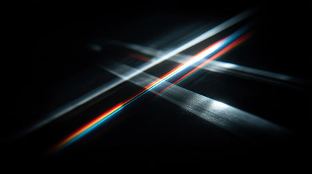 This image presents intersecting light beams against a dark backdrop. The streaks of light display a blend of colors and create a dynamic visual effect. The composition uses a dark, minimalist style, suitable for various design applications. It might be suitable for graphic design projects or artistic representations.の素材