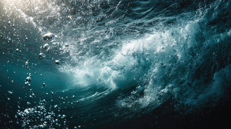 An underwater perspective captures swirling ocean water with sunlight breaking through. The image shows shades of blue and white, with visible bubbles and textures of the water. The dynamic composition could be used for various commercial projects related to nature or aquatic themes.の素材