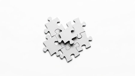 Several white puzzle pieces interlock on a plain white backdrop. The composition is clean and minimalist, with soft lighting enhancing the textures. The image suggests concepts of problem-solving, teamwork, and integration. Suitable for use in a variety of commercial and editorial projects.の素材