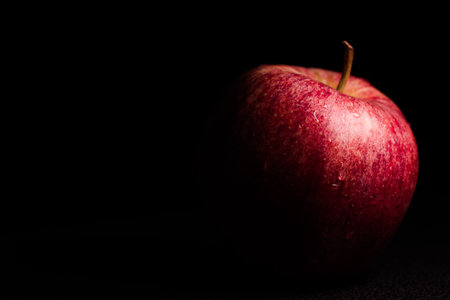 Red apple with water drops on a black background. Copy space.の写真素材