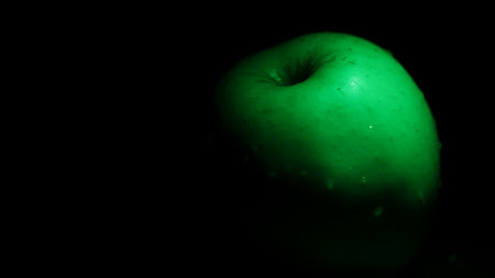 Green apple on a black background. Close-up. Selective focus.の写真素材