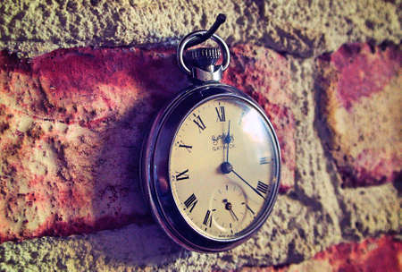 Vintage pocket watch hung from brick wall, Parksville, BC.の写真素材