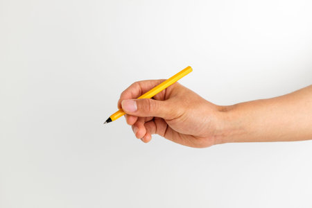 Handwriting posture. Pen gripping. writing. Hand holding an orange pen