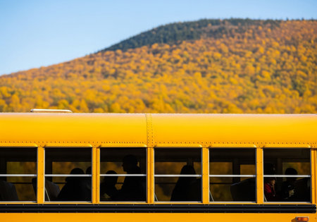 Side View of a School Bus with an Autumn Mountain Landscapeの素材