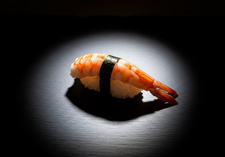 A Dramatic Shot of a Single Ebi Nigiri Sushi Under a Spotlightの素材