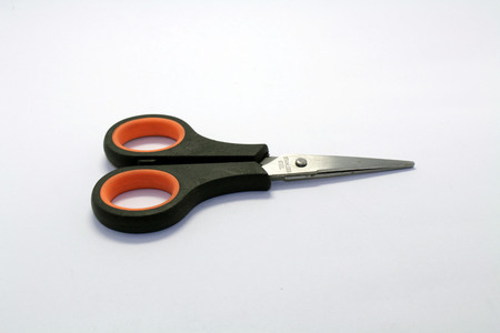 The scissors, a black one with some orange strip. A trivial but essential stationery.の写真素材