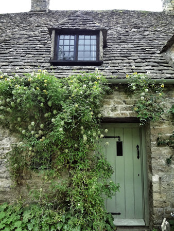 Stone house with green door and ivy , Cotswold 