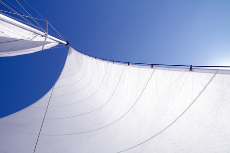 filled with wind sail sunlit blue sky backgroundの写真素材