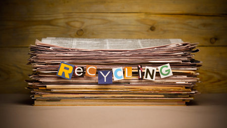 stack of old newspapers labeled recycling