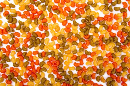 multicolored pasta evenly spilling on a white backgroundの写真素材