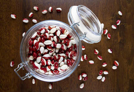 red and white beans in a glass jar on the table top viewの写真素材