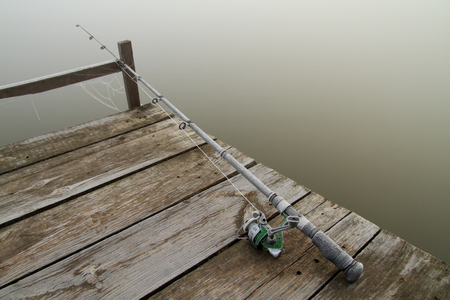 fishing rod frosted on the wooden bridgeの写真素材