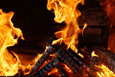 burnt wooden logs are covered with flame in an open ovenの写真素材