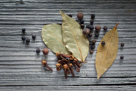 cloves, pepper and bay leaf on the old board. top viewの写真素材