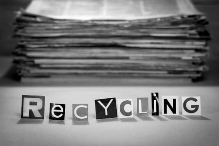 Recycling sign on a blurred background of old newspapers. Black and white photoの写真素材