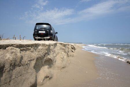 Off-road car on sand on seacoastの写真素材