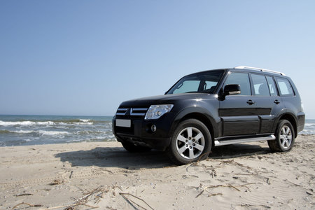 Off-road car on sand on seacoast