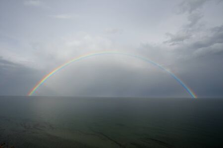 Rainbow on seacoast after a summer thunder-stormの写真素材