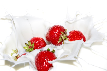 Falling a strawberry with milk splashesの写真素材