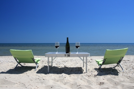 Wine glasses standing on a table on seacoastの写真素材