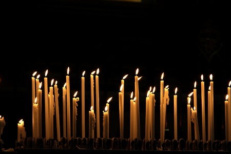 Burning candles in cathedral Duomo in Milanの写真素材