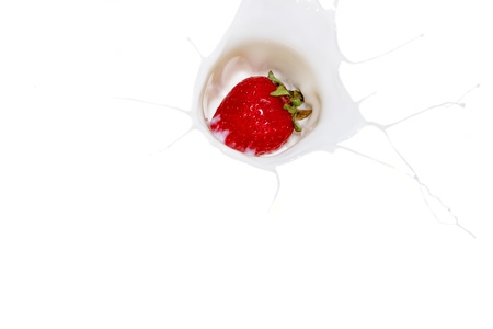 Falling a strawberry with milk splashesの写真素材