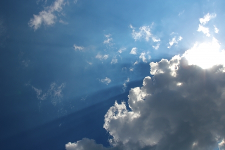 Clouds bathing in solar beams in the blue skyの写真素材