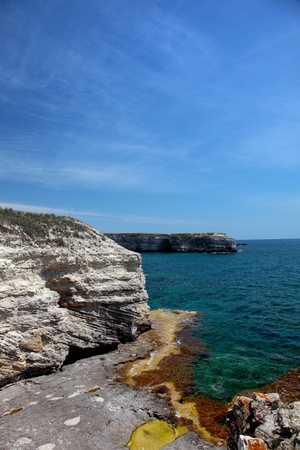 Stone rock on seacoast and blue seaの写真素材